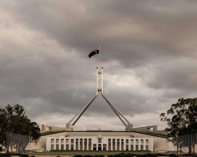The Parliament House of Australia in Canberra with a dramatic cloudy backdrop.
