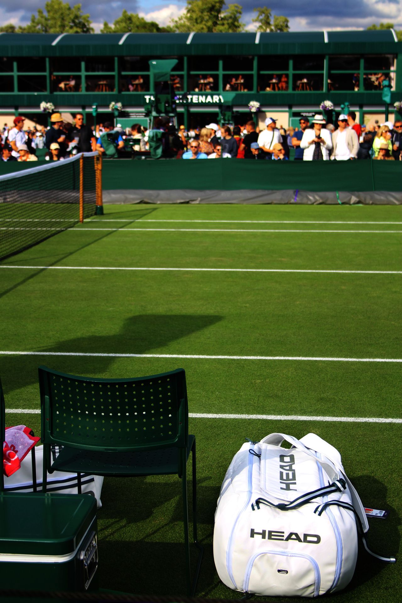 Wimbledon grass court with HEAD tennis bag and spectators